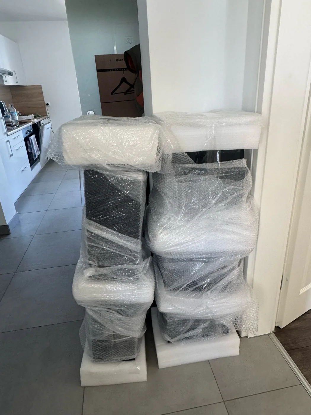 In Luftpolsterfolie verpackte Sessel, gestapelt im Flur einer Wohnung