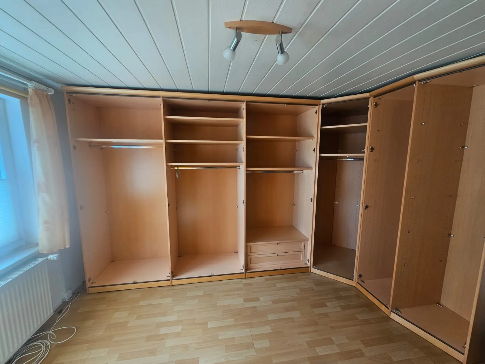 Zerlegter Einbauschrank: die offenen Korpusse stehen an der Wand des leeren Zimmers