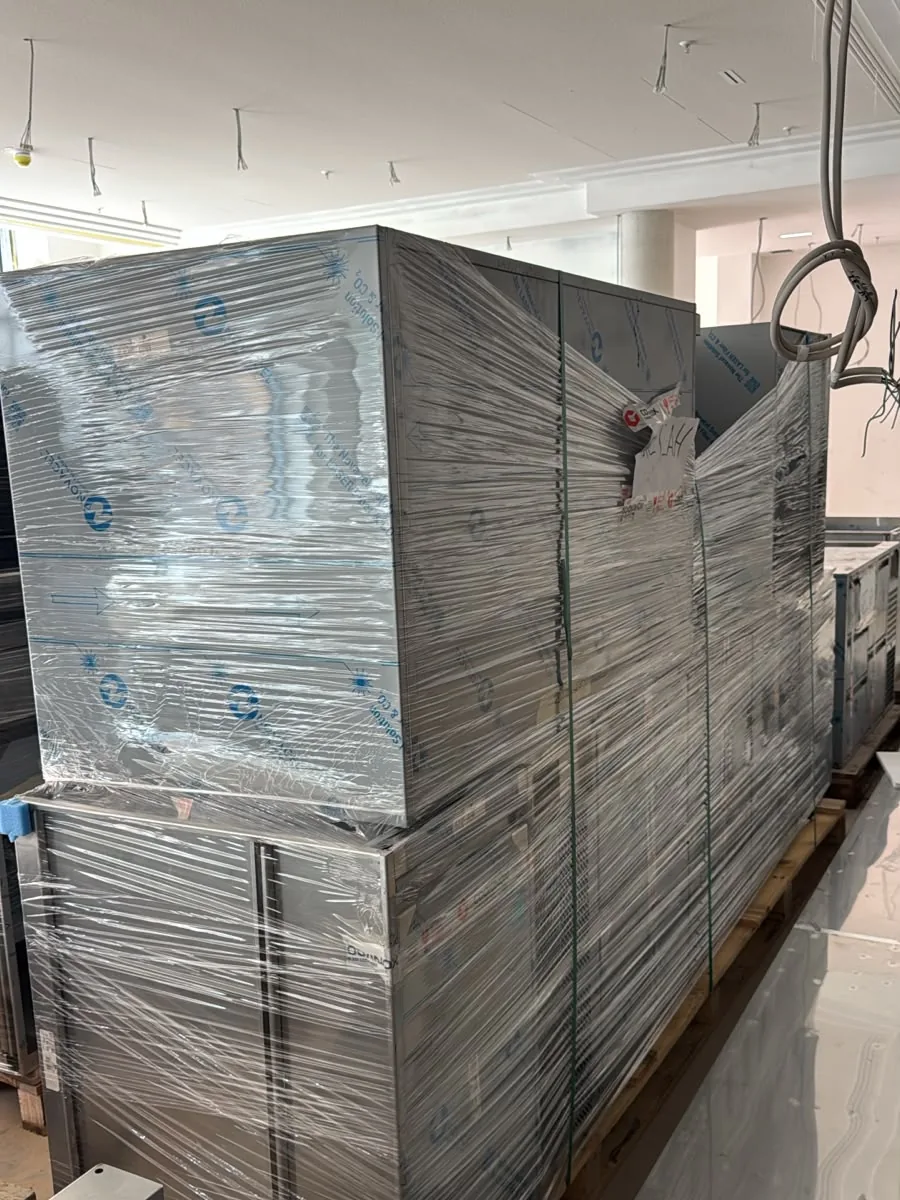 Schweres Gerät auf einer Palette, mit Folie und Holzlatten für den Transport gesichert